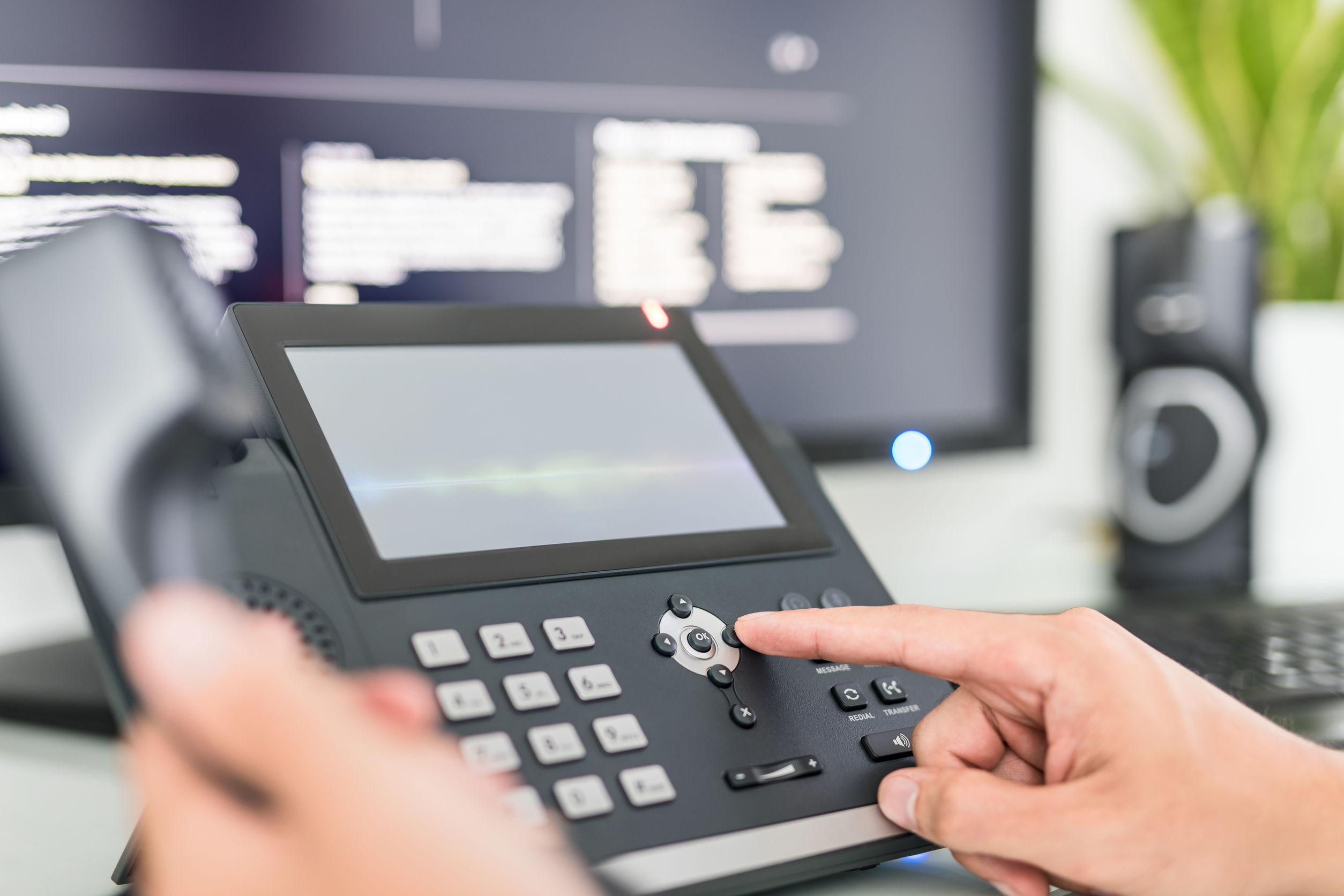 Hand interacting with office phone