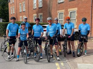 Cherry & White cycling team in blue jerseys with bikes on day one of the Tour de BT