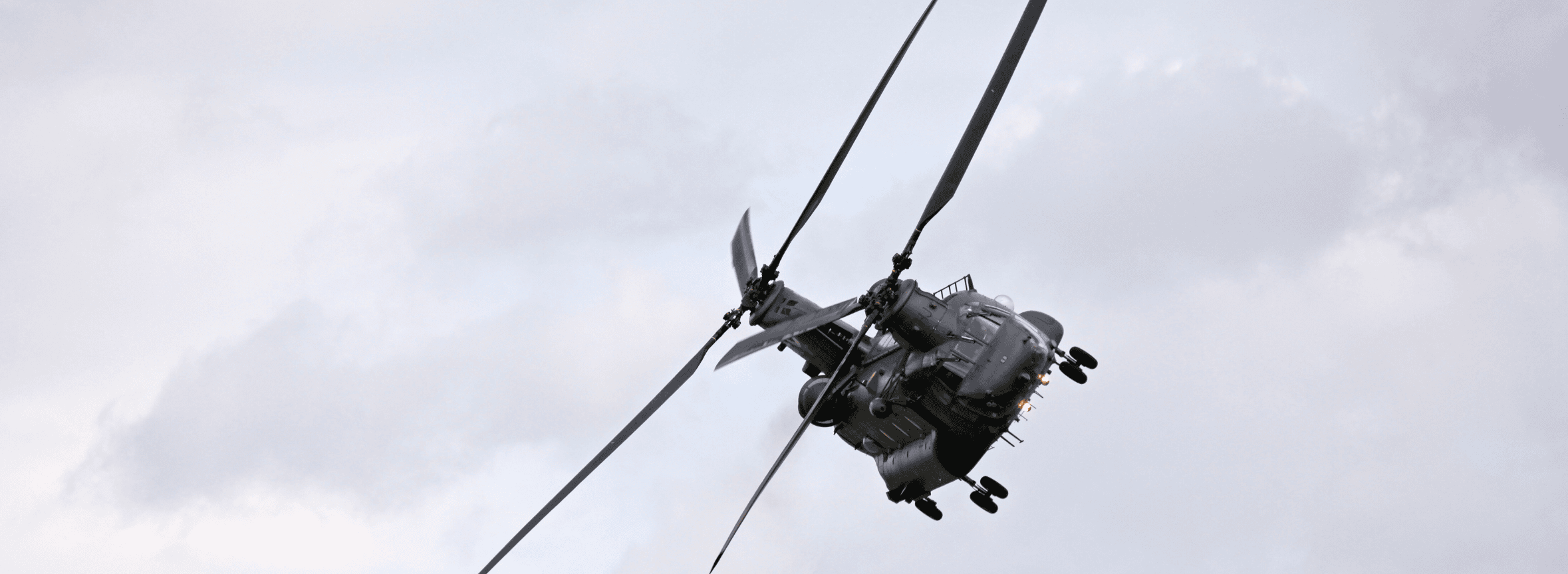 Chinook helicopter flying in a grey sky, defence solutions banner