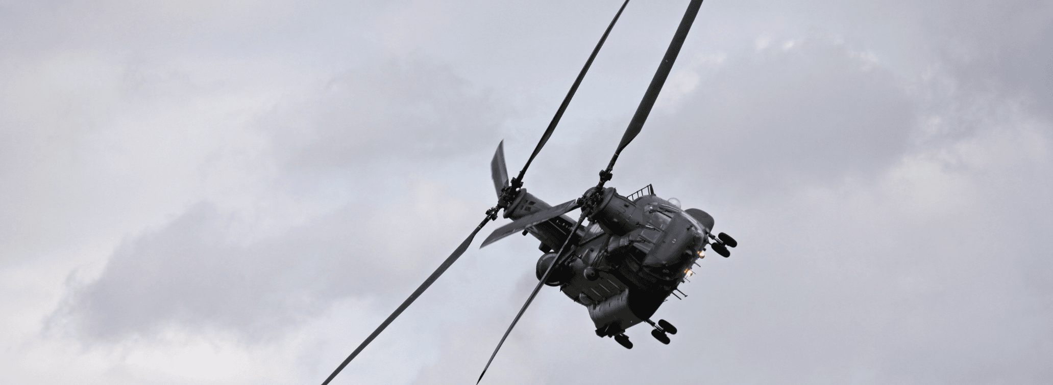 Military helicopter in flight against an overcast sky