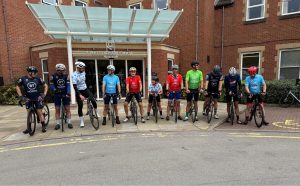 Tour de BT group photo with bikes outside a hotel on day three
