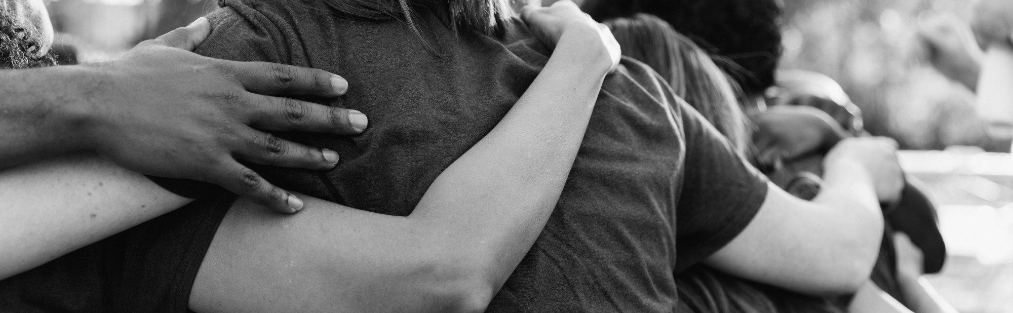 Black and white photo of two people hugging, charity events banner
